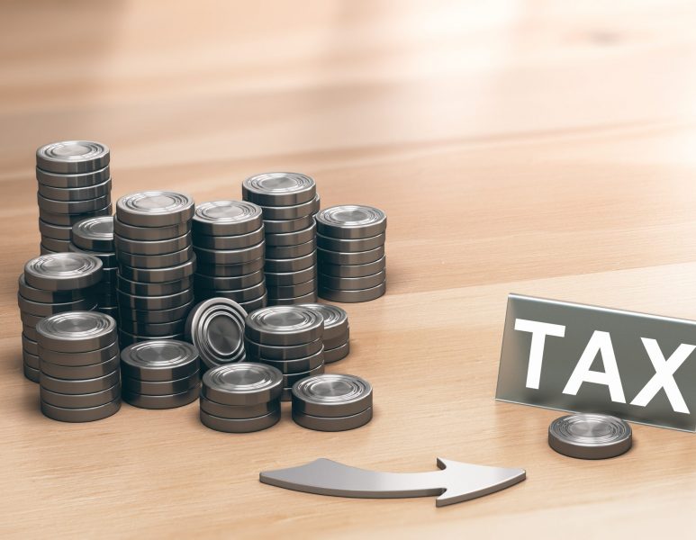 Piles of coins symbols on a wooden table and an arrow pointing a single coin with the word tax. Financial advisory and tax planning concept. 3d illustration.